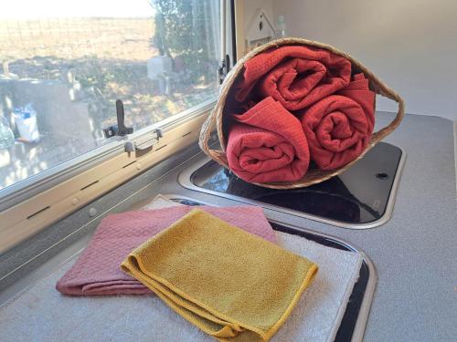 un cesto di asciugamani seduto su un bancone accanto a una finestra di Camping car à 3 minutes du parc Pairi Daiza a Brugelette