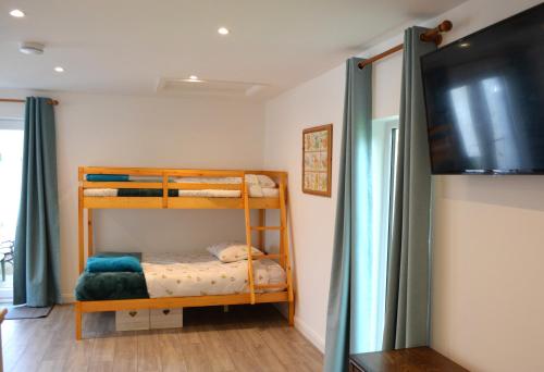 a bedroom with two bunk beds and a television at Family Retreat or Romantic Break 