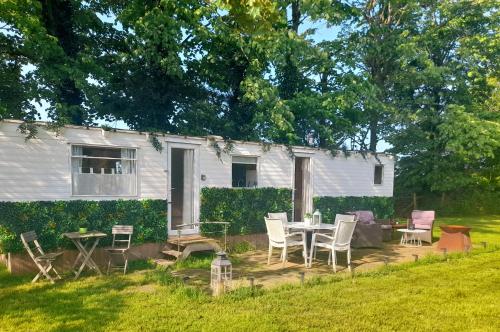 een patio met een tafel en stoelen voor een huis bij Delightful tiny home in the middle of nature. 