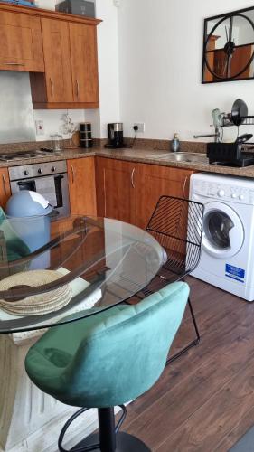 a kitchen with a glass table and a washing machine at Chi's Lodge in Purfleet