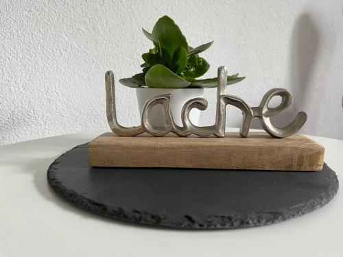 a metal sign that says home with a potted plant at Appartement Seehof in Nassereith