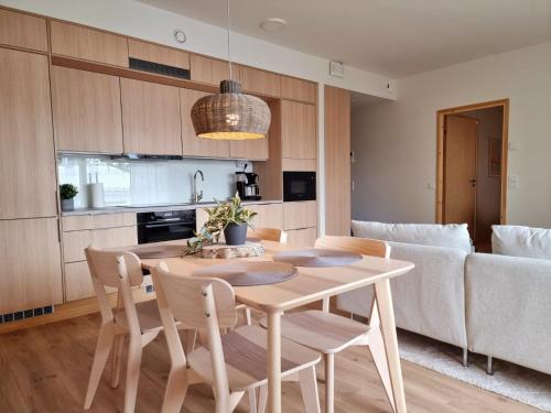 Kivikatu Apartment في روفانييمي: مطبخ وغرفة معيشة مع طاولة وكراسي