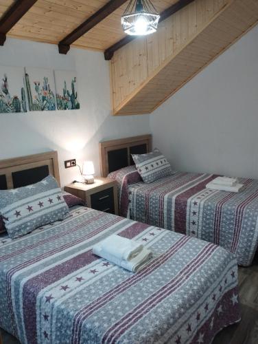 a bedroom with two beds and a ceiling at Haza Del Puente in Riópar