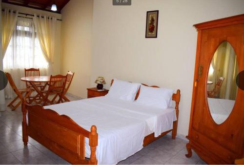 a bedroom with a large bed and a table with a chair at Reverie Hill Bungalow, Kandy in Kandy