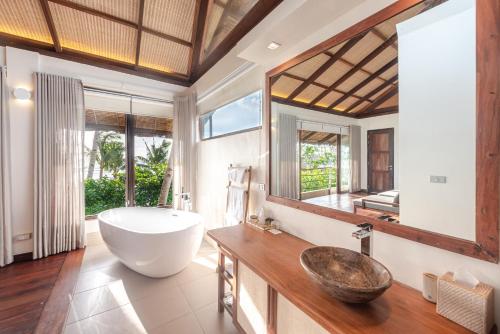 a bathroom with a large tub and a sink at L'Osteria Luxe Beachfront B&B in General Luna