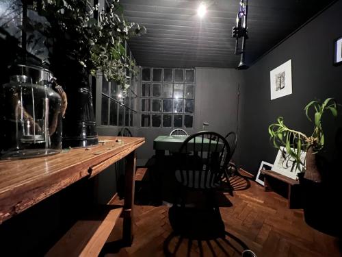 Habitación oscura con mesa de madera y sillas. en Banícka chalupa U felčiara en Banská Bystrica