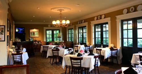 un ristorante con tavoli e sedie con tovaglie bianche di Anchuca Historic Mansion & Inn a Vicksburg
