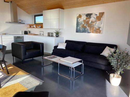 a living room with a black couch and a table at Seaside Rendezvous in Kalana