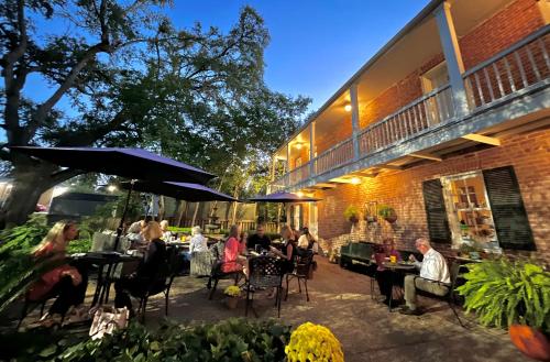 a group of people sitting at tables outside of a building at Anchuca Historic Mansion & Inn in Vicksburg