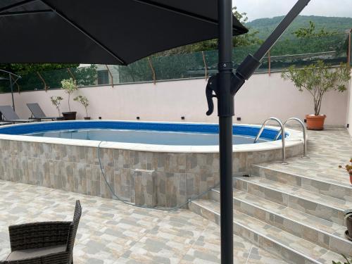 ein Regenschirm neben einem Pool in der Unterkunft APARTMAN BUKULJA 2 in Aranđelovac