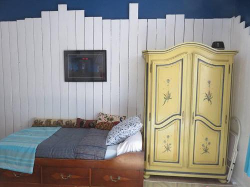 a bedroom with a bed and a yellow cabinet at Studio (T1) quartier Cathédrale in Tours