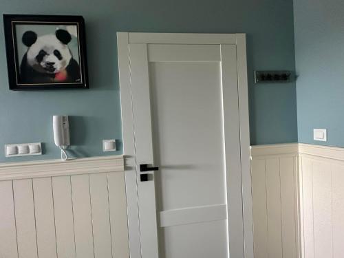 a room with a door with a panda picture on the wall at Apartament na Wzgórzu Miętowy in Łańcut
