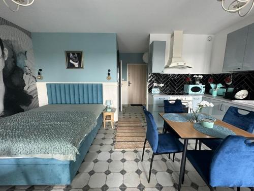 una camera con letto e tavolo e una cucina di Apartament na Wzgórzu Miętowy a Łańcut