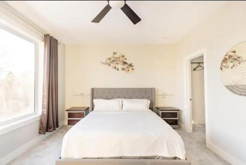 Burj Arab Luxury في Tower Grove: غرفة نوم بيضاء مع سرير ومروحة سقف