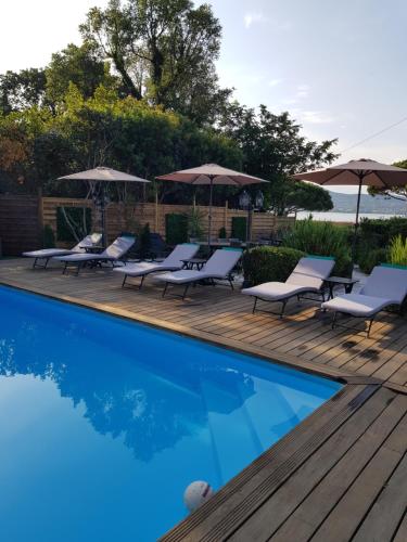 a swimming pool with lounge chairs and umbrellas at Hotel Villa Maya in Saint-Tropez
