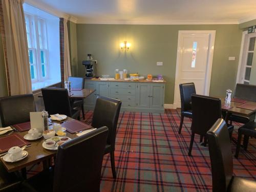 a dining room with tables and chairs and a counter at The Delnashaugh in Ballindalloch
