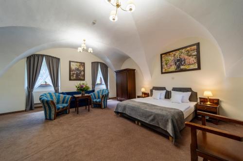 1 dormitorio con 1 cama y sillas en una habitación en Zamek Kliczków en Kliczków