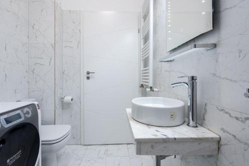 a white bathroom with a sink and a toilet at Smart Duplex in Bucharest