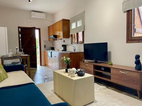 a living room with a tv and a kitchen at almond home in Livadia