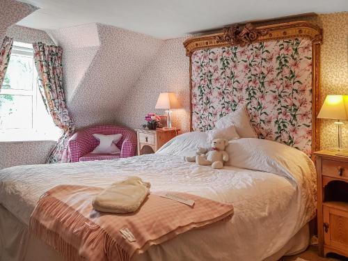 クリフにあるIvy Cottageの寝室のベッドに座るテディベア