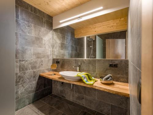 a bathroom with a sink and a mirror at Alpenchalets Oberlaiming in Itter