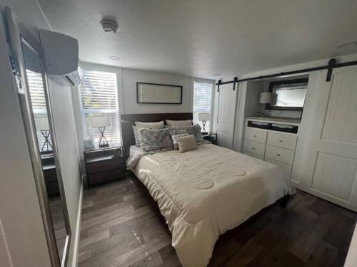 a bedroom with a bed and a television in it at Fox Hollow - Tiny home with Cypress Creek access, park like setting in Wimberley