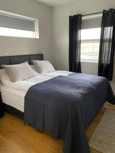 um quarto com uma cama grande e uma janela em Strýta 4 em Ölfus