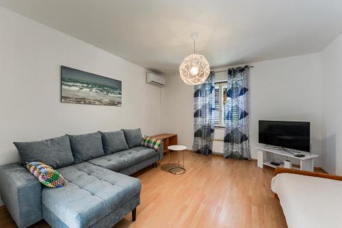 - un salon avec un canapé et une télévision dans l'établissement Apartman Klarin, à Zadar
