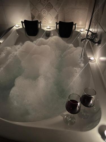 a bath tub filled with snow with two glasses of wine at La Mary in Old Town in Sibiu