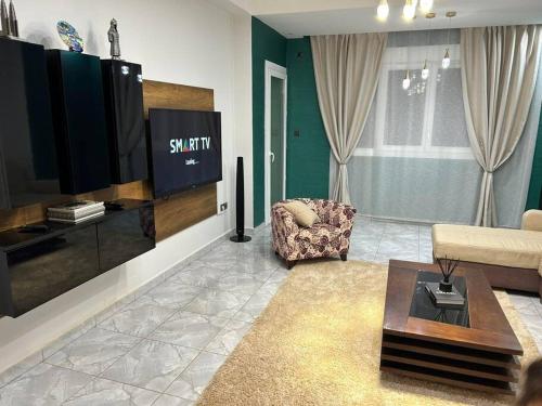 een woonkamer met een tv en een bank en een stoel bij Appartement Ghazaouet in Ghazaouet