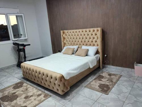 a bedroom with a large bed with a large headboard at Appartement Ghazaouet in Ghazaouet