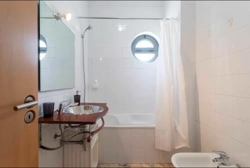 a bathroom with a sink and a bath tub at Arrábida Resort in Quinta do Anjo