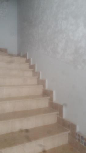 a set of stairs in a room with a stair case at belabbes in Taourirt