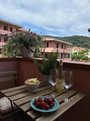 einen Tisch mit einem Teller mit Speisen und Weingläsern in der Unterkunft Agave Marina in Marciana Marina