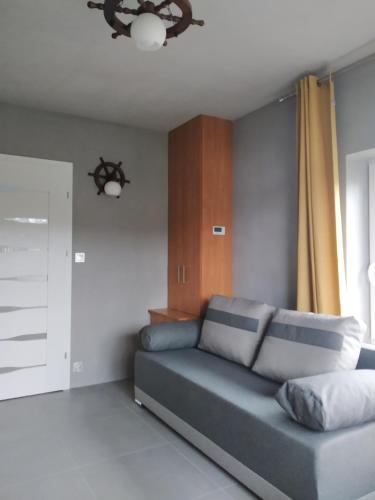 a living room with a blue couch and a window at Domek Natalia in Giżycko