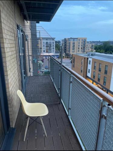 a white chair sitting on the balcony of a building at Spacious Amazing Luxury En-suite double room with free parking in a two bedroom apartment in Belvedere
