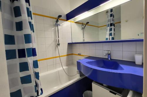 La salle de bains est pourvue d'un lavabo bleu et d'une baignoire. dans l'établissement St RAPHAEL - CAP ESTEREL Location Colette, à Saint-Raphaël