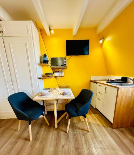 une petite cuisine avec une table et deux chaises dans l'établissement Studio Hissez Haut - idéalement placé, plage, restaurants, commerces, à Trouville-sur-Mer
