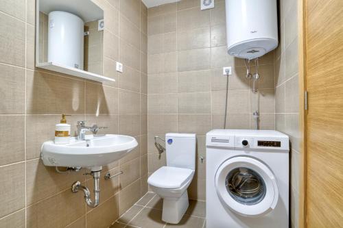 a bathroom with a toilet sink and a washing machine at Sigma apartment in Budva