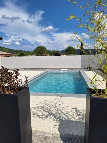 une piscine dans l'arrière-cour d'une maison dans l'établissement Chez Louise et Juliette, à Vallon-Pont-dʼArc