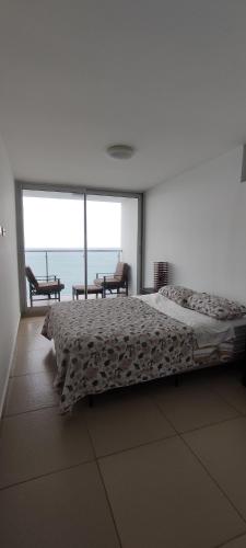 1 dormitorio con cama y vistas al océano en Ph El Palmar Residenses, en El Nance