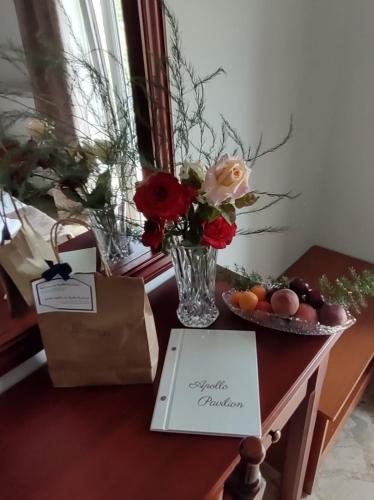 a table with a vase of flowers and a bag at Apollo Pavilion Apartments in Mirina