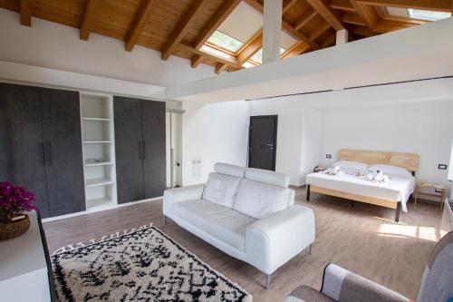 - un salon avec un canapé blanc et un lit dans l'établissement Ca' Lisa e Sofia, à Lezzeno