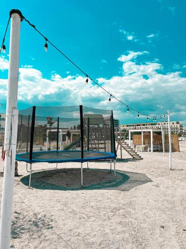 a swing set in the sand on a beach at Hotel Victory in Mamaia