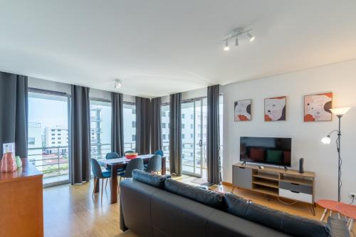 a living room with a couch and a tv and a table at Atlantic West Town in Ponta Delgada