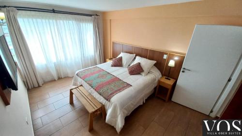ein Schlafzimmer mit einem Bett und einem großen Fenster in der Unterkunft Villa Ober Suites in Dina Huapi