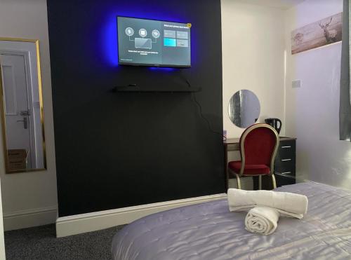 a bedroom with a bed and a tv on a wall at Hotel Royal Blackburn in Blackburn