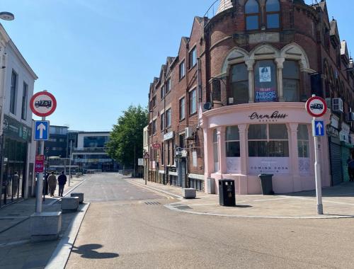 an empty street in a city with a pink building at Hotel Royal in Blackburn