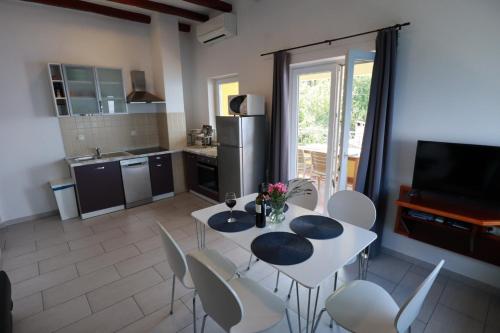 cocina con mesa blanca y sillas en Accommodation Salvia en Sveti Juraj