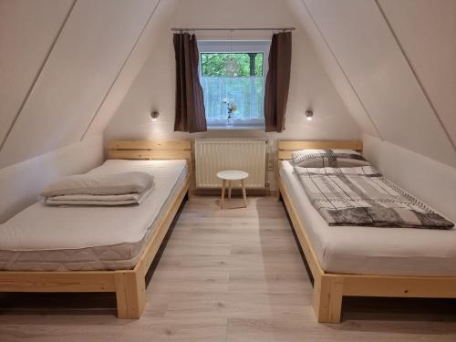 two beds in a small room with a window at Ferienhaus Marpe 125 in Bad Arolsen